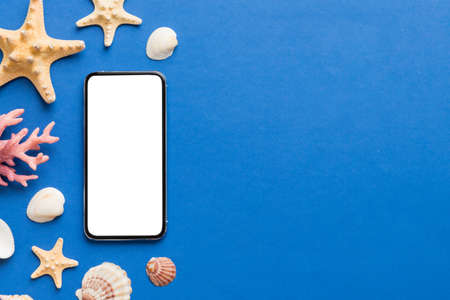 Flat lay composition with Phone and beach accessories on colored background. Smartphone with blank...