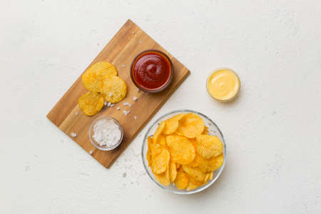 Top view chips with sause in bowl on colored background, top view with copy space.の写真素材