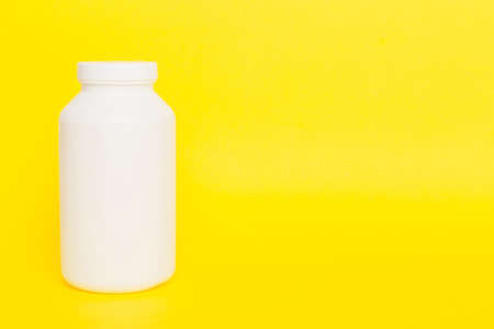 supplement pills with medicine bottle health care and medical top view. vitamin tablets. Top view mockup bottle for pills and vitamins with green leaves, natural organic bio supplement, copy space.の写真素材