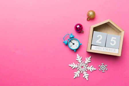 Christmas wood calendar with new year decorations, aganist colored background. Christmas calendar 25...