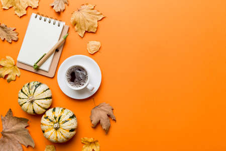 Flat lay composition with colorful Autumn cup of coffee and leaves on a color background. top view.の写真素材
