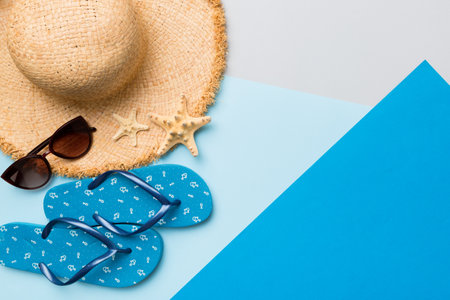 Summer vacation concept flat lay. straw hat beach accessories and flip flop top view. Space for...