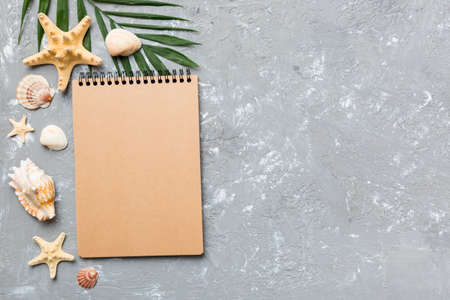 Blank writing book with summer beach accessories on background, copy space. Flat lay with copy...
