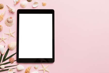 Flat lay composition with tablet and beach accessories on colored background. Tablet computer with blank screen mock up with copy space.の写真素材