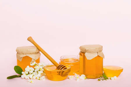 robinia honey bollte with acacia blossoms on colored table.