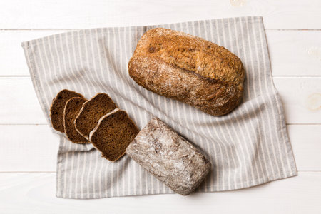Freshly baked bread slices on napkin against natural background. top view Sliced bread.