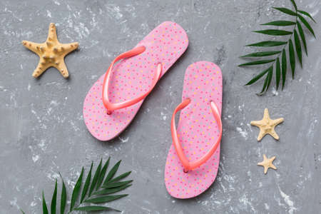 Flat lay composition with flip flops and seashell on colored background. Space for text view.