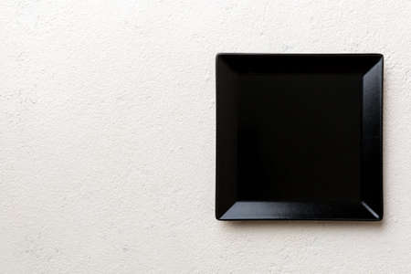 Top view of empty square plate on cement background. Empty space for your design.