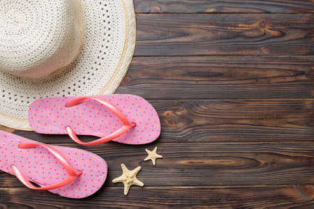 Summer travel concept. Flip flops, summer hat and starfish on white. Top view on colored background.の写真素材