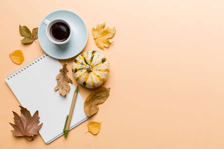 Autumn composition: fallen leaves and notebook mock up on colored background. top view. Flat lay...