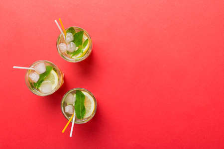 Caipirinha, Mojito cocktail, vodka or soda drink with lime, mint and straw on table background. Refreshing beverage with mint and lime in glass top view flat lay.の写真素材