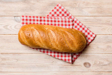 freshly baked bread with napkin on rustic table top view. Healthy white bread loaf isolated.