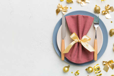 Christmas table place setting with christmas decor and plates, kine, fork and spoon. Christmas holiday background. Top view with copy space.の写真素材