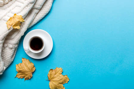Flat lay composition with colorful Autumn cup of coffee and leaves on a color background. top view.