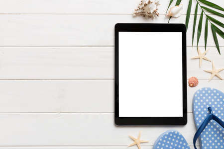 Flat lay composition with tablet and beach accessories on colored background. Tablet computer with blank screen mock up with copy space.の写真素材