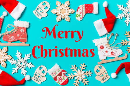 Merry christmas text. Top view of Christmas decorations and Santa hats on blue background. Happy holiday concept with copy space.の写真素材