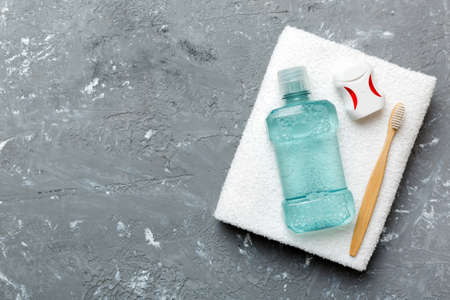 Mouthwash and other oral hygiene products on colored table top view with copy space. flat lay. dental hygiene. Oral care products and space for text on light background. concept.の写真素材