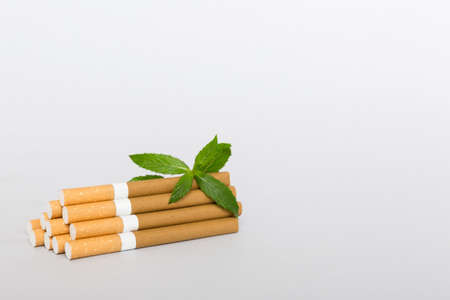 Menthol cigarettes and fresh mint leaves on colored background, Many cigarettes stacked together top view flat lay.の写真素材