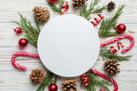 Flat lay Christmas composition. Round Paper blank, pine tree branches, christmas decorations on Colored background. Top view, copy space for text.の写真素材