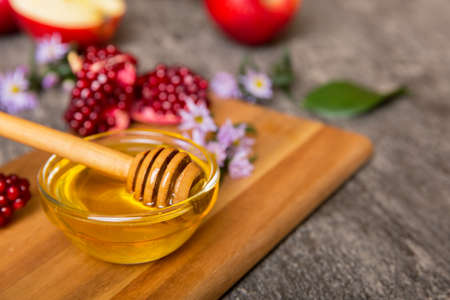 Rosh hashanah, jewish holiday, concept: honey, apple and pomegranate with cutting board, close up.の写真素材