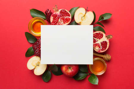 Flat lay composition with Blank flyer poster and symbols jewish Rosh Hashanah holiday attributes on colored background, New Year holiday Traditional. Top view with copy space mock up.の写真素材