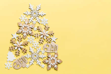 Christmas tree made from colored snowflakes decoration on colored background, view from above. New Year minimal concept.の写真素材