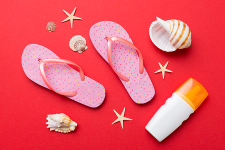 Summer travel concept. beach accessories. Flip flops and starfish on white. Top view on colored...