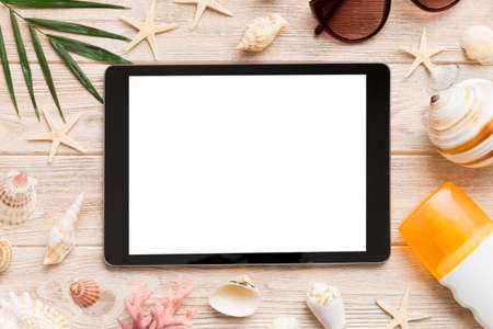 Flat lay composition with tablet and beach accessories on colored background. Tablet computer with blank screen mock up with copy space.の写真素材