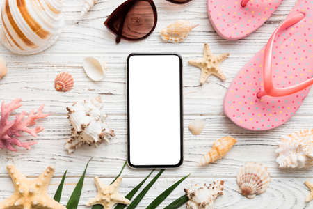 Flat lay composition with Phone and beach accessories on colored background. Smartphone with blank screen mock up with copy space.の写真素材