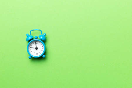 Alarm clock isolated on colored background with copy space top view.