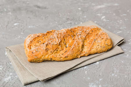 freshly baked bread with napkin on rustic table top view. Healthy white bread loaf isolated.