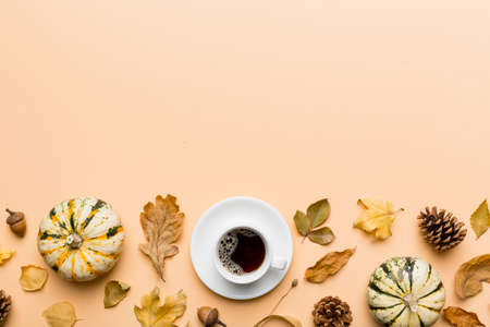 Flat lay composition with colorful Autumn cup of coffee and leaves on a color background. top view.の写真素材