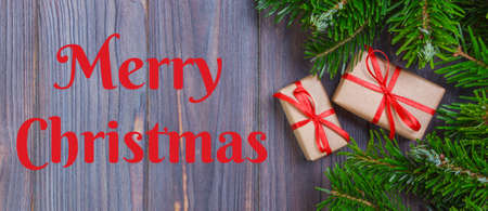 Merry christmas text. Christmas background with Christmas gift on wooden background with Fir...