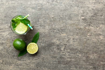 Caipirinha, Mojito cocktail, vodka or soda drink with lime, mint and straw on table background. Refreshing beverage with mint and lime in glass top view flat lay.の写真素材
