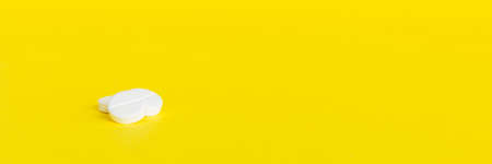 Heap of white pills on colored background. Tablets scattered on a table. Pile of red soft gelatin...