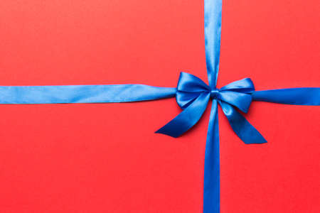 Top view of purple ribbon rolled and pink bow isolated on colored background. Flat lay with copy space.の写真素材