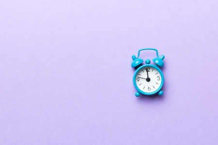 Alarm clock isolated on colored background with copy space top view.