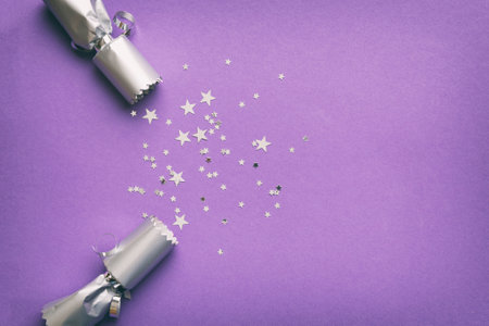 Christmas crackers with shiny confetti on color background, top view, copy space.の写真素材