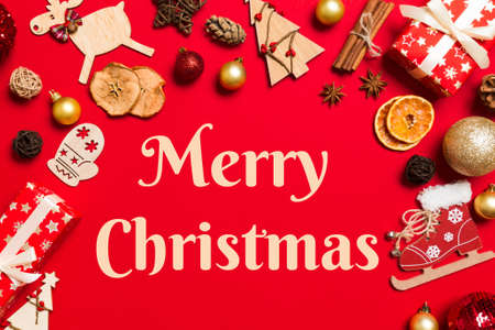 Merry christmas text. Top view of Christmas decorations on red background. New Year holiday concept...