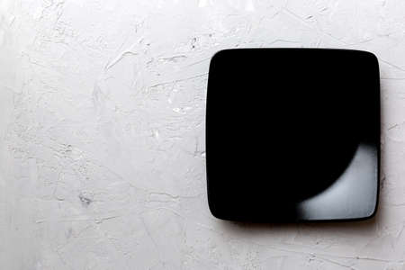 Top view of empty square plate on cement background. Empty space for your design.の写真素材