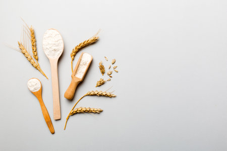 Flat lay of Wheat flour in wooden bowl with wheat spikelets on colored background. world wheat crisis.の写真素材