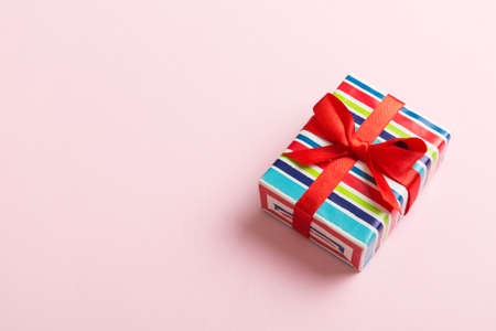 Wrapped christmas or other holiday handmade present in paper with colored ribbon. Present box,...