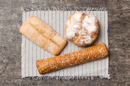 Assortment of freshly baked bread with napkin on rustic table top view. Healthy unleavened bread....