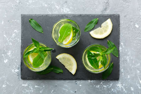 Caipirinha, Mojito cocktail, vodka or soda drink with lime, mint and straw on table background. Refreshing beverage with mint and lime in glass top view flat lay.の写真素材