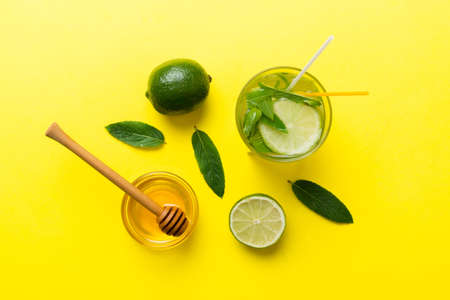 Caipirinha, Mojito cocktail, vodka or soda drink with lime, mint and straw on table background. Refreshing beverage with mint and lime in glass top view flat lay.の写真素材