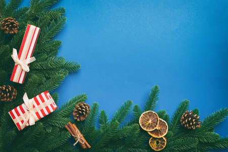 Christmas decorations and fir tree branch and gift boxon dark table. Top view frame with copy space.
