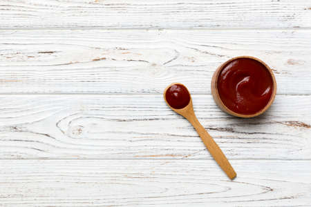 Tasty Tomato Ketchup sauce in wooden bowl with spoon on wood background. Top view with copy space.の写真素材