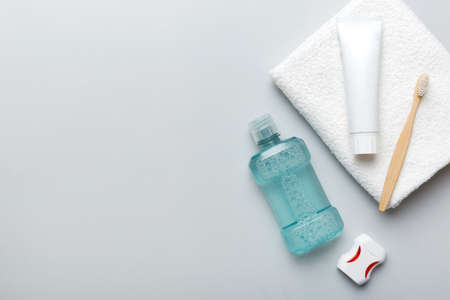 Mouthwash and other oral hygiene products on colored table top view with copy space. flat lay. dental hygiene. Oral care products and space for text on light background. concept.の写真素材