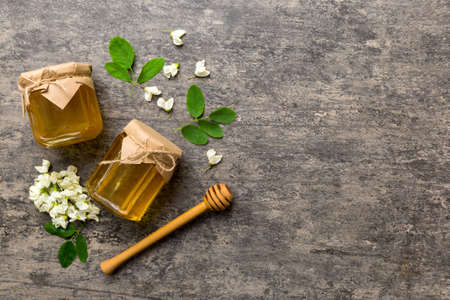 honey jar with acacia flowers and leaves. fresh honey top view flat lay.