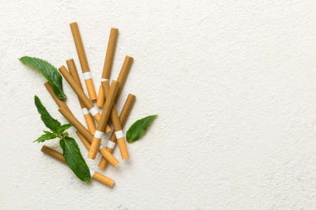Menthol cigarettes and fresh mint leaves on colored background, Many cigarettes stacked together top view flat lay.の写真素材